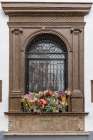 Andujar, Andalusia, Spain. Cut flowers decorating a barred window on an old Spanish building. Art Print